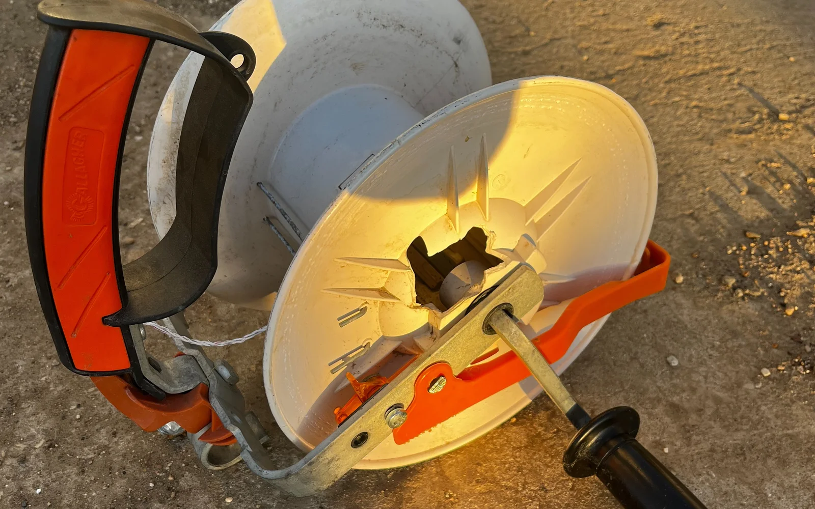 Commercial electric fence reel with a broken white spool shell