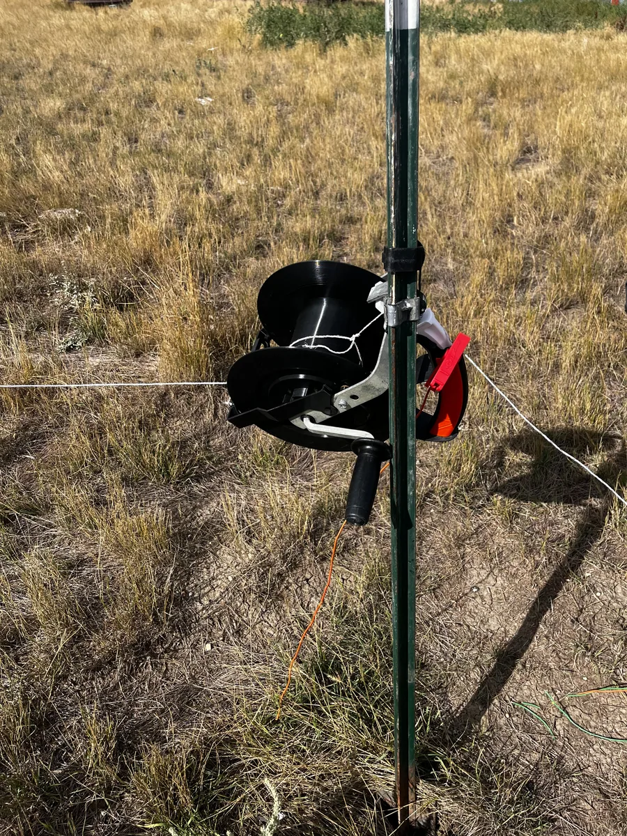 Close view of a field-tested electric fence reel showing the spool and ratchet interface