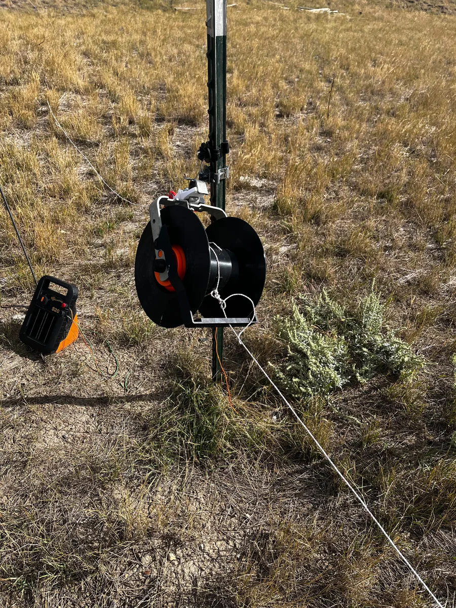 Electric fence reel operating on a fence post in a South Dakota pasture